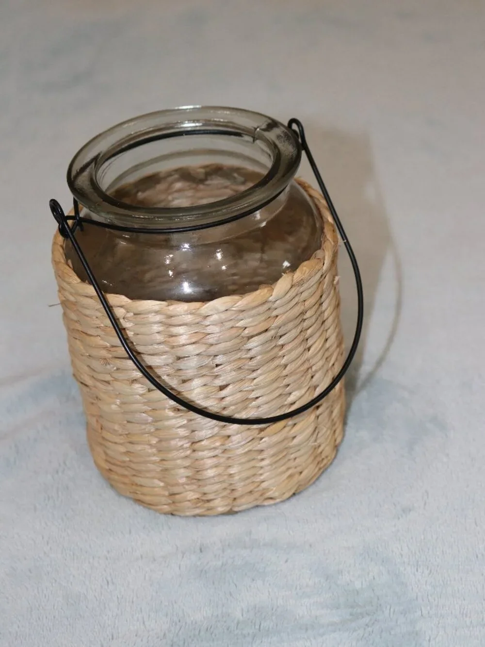 Glass and wicker flower vase with handle.